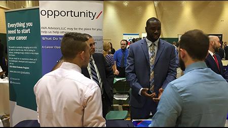 Two students speaking with an employer at a career fair