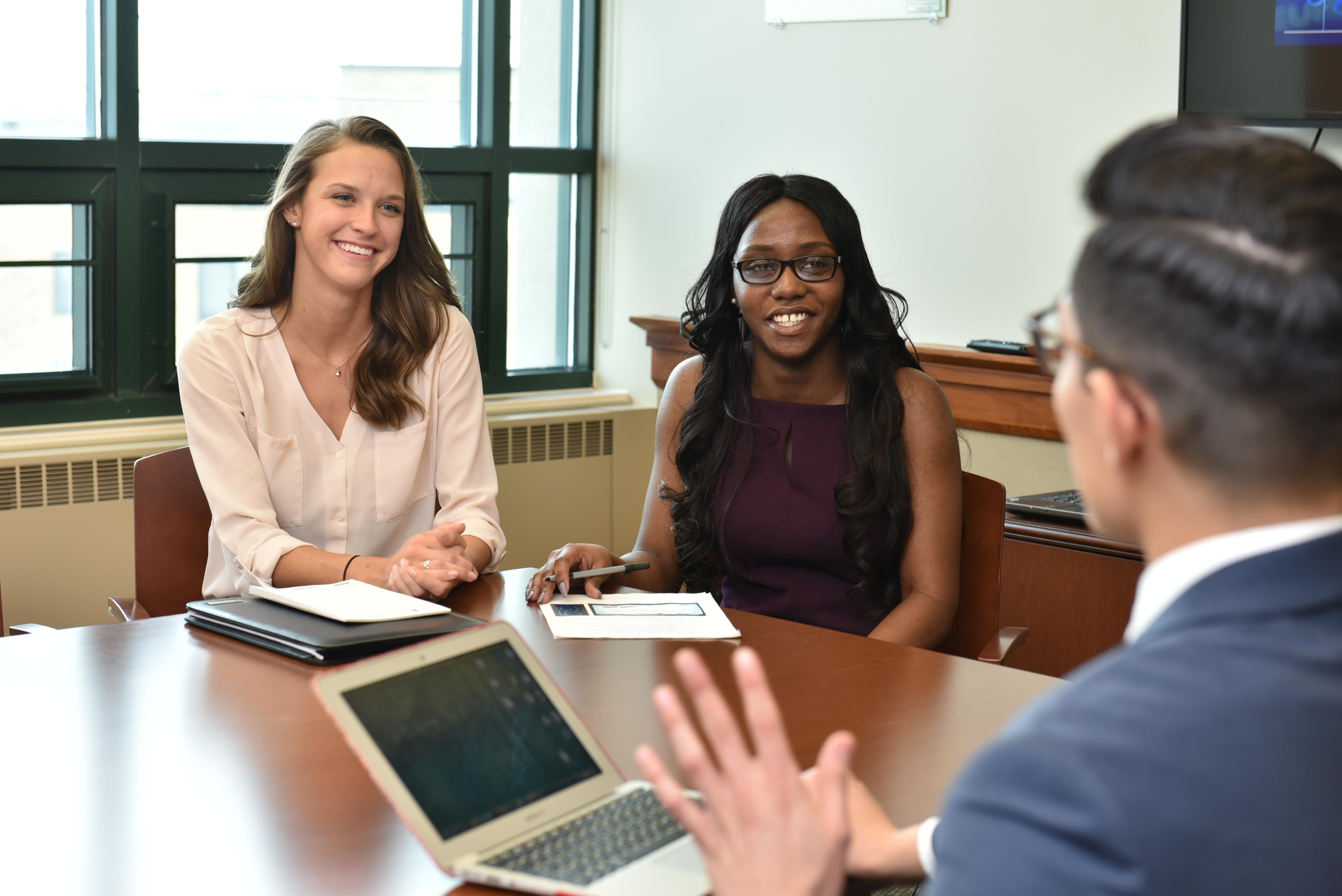 Two students being interviewed by an employer