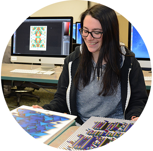 Graphic design student reviewing project in computer lab