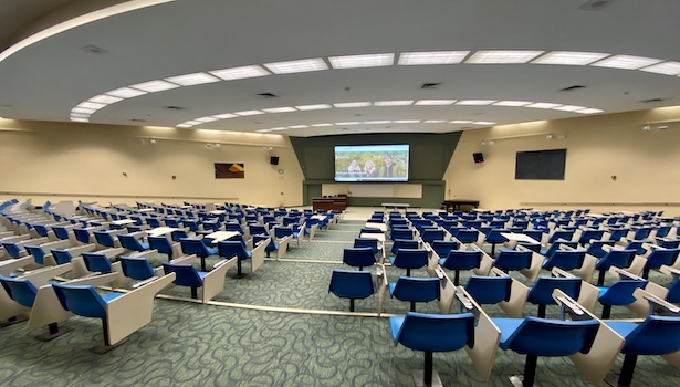 Photo of the back of the classroom from the center. Including the screen/podium/seats. 