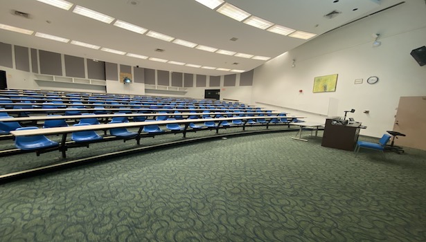 Photo shows the classroom from the right hand side showing the podium and student chairs. 