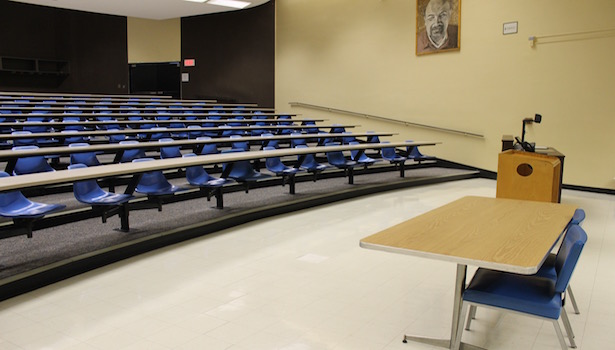 This is a side view of the classroom with the seats, professor table and side of the podium.