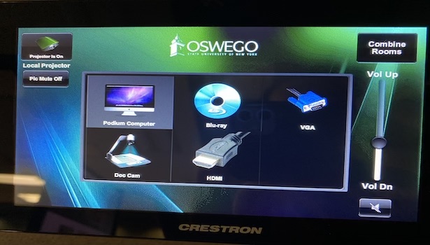 Photo shows the Crestron Touch Screen in the room. 