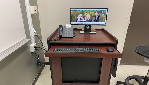 Photo shows the podium in this classroom including the PC with the handicapped side table down.  