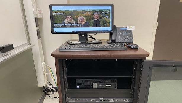 Photo shows the podium in this classroom including the PC and phone. 