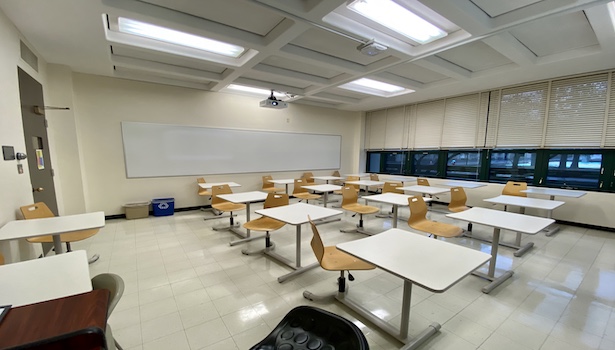 Photo shows the classroom from the podium perspective including chairs and projector. 