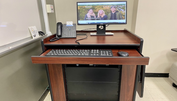 Photo shows the podium in this classroom including the PC and phone. 