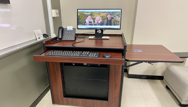 Photo shows the podium in this classroom including the PC and the handicapped side table. 