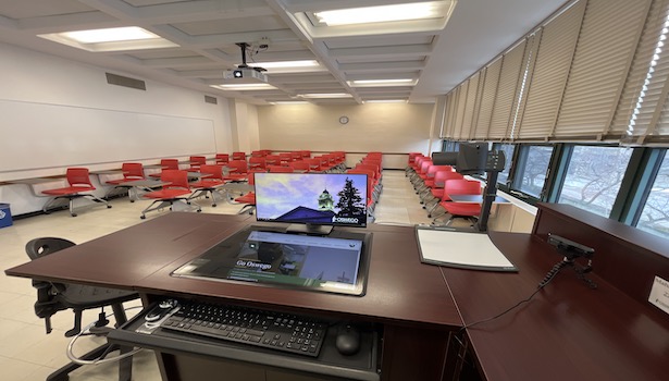 photo of the classroom from the podium including second monitor, student chairs and projector. 