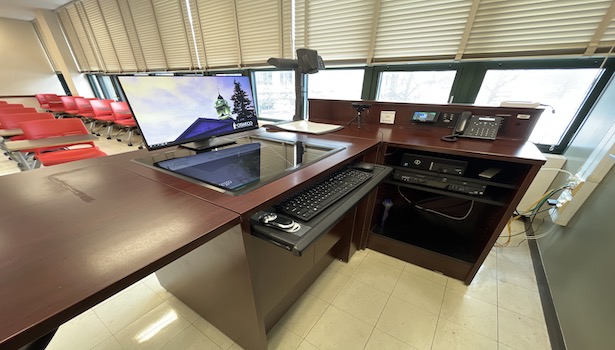 photo of the podium in the room including document camera, PC, DVD/VHS player. 
