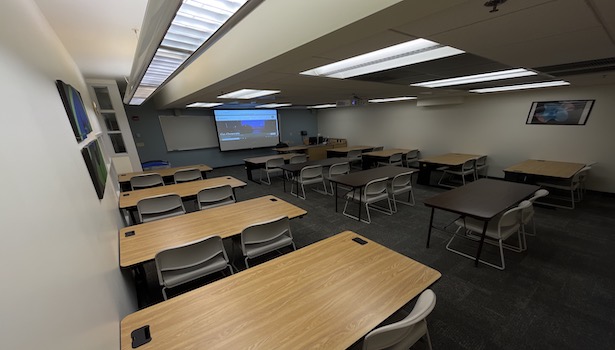 photo from the back of the room to show the entire classroom. including projector screen and student chairs. 