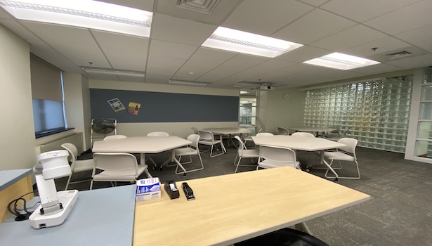 Photo shows the classroom from the podium perspective including chairs and the projector. 