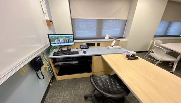 Photo shows the podium in the classroom including the PC, touch panel, document camera and phone. 