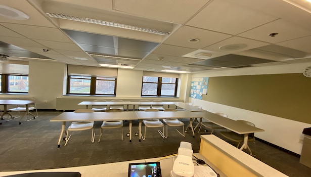 Photo shows the classroom from the podium perspective on the right side. Showing student chairs and the document camera. 