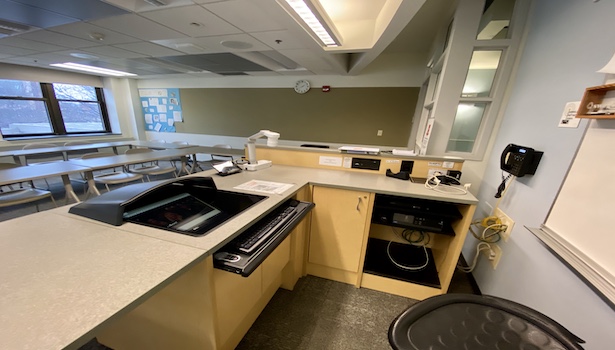 Photo shows the podium in this classroom including PC, Doc Cam, Blu Ray player and phone. 