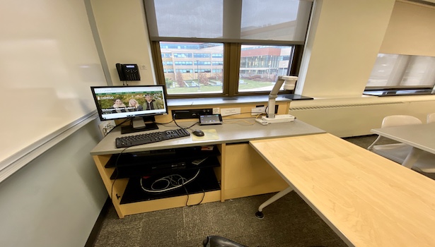 Photo shows the podium in the classroom including the PC, touch panel, document camera and phone. 