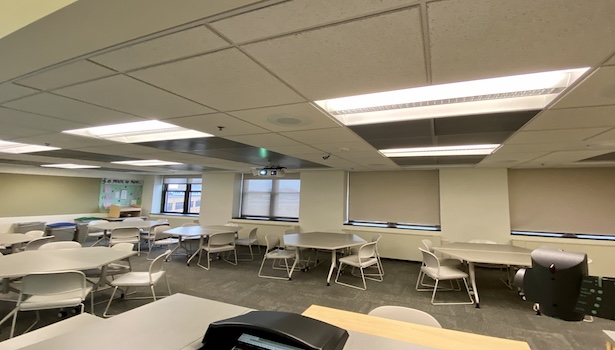 Photo shows the back of the classroom from the podium perspective. Including the Doc cam, PC and student chairs. 