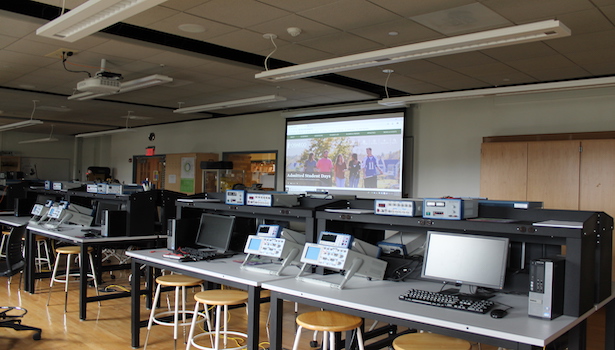 This photo shows the back of the classroom with all of the seats and the large projector screen. 