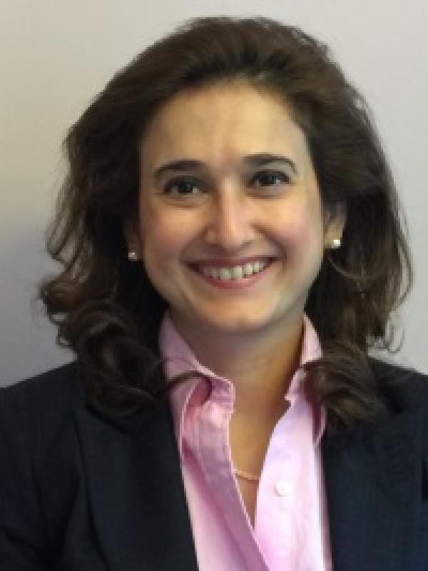 Picture of a woman smiling against pale grey backdrop
