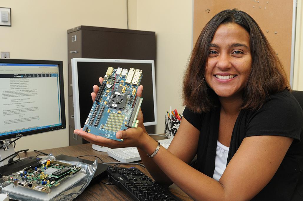 Professor Marianne Hromalik holding the XPRESS FX Virtex-4 FPGA board for development