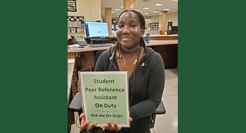 Perr Reference Assistant Rochelle holding sign