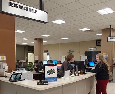 Student asks her question at the Research Help Desk.