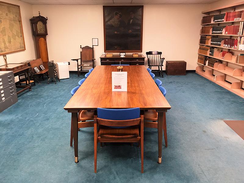 The Archives & Special Collections visiting room has 10 seats around a wooden table.