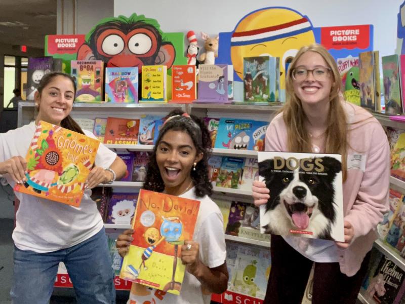 SUNY Oswego Empire State Service Corps member Ruby Remseyer makes friends while supporting a book fair at Leighton Elementary School in Oswego