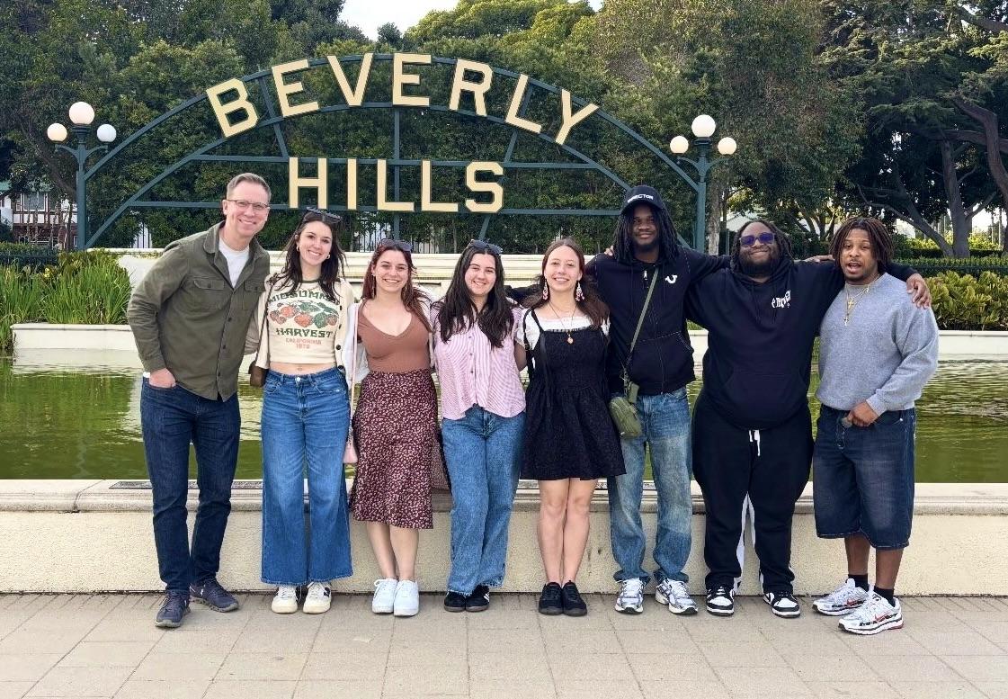 Oswego students and faculty member Michael Riecke stand in front of the Beverly Hills sign on the 2025 Hollywood POV trip.