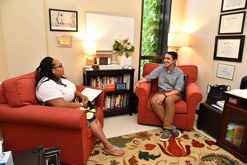 Cara Plasencia (left), a senior counselor at the Counseling Services Center, talks in her new office with colleague Kyle R. Dzintars, outreach coordinator and senior counselor.