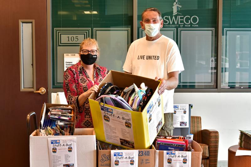 SUNY Oswego State Employees Federated Appeal co-chair Cathy Johnston and Patrick Dewine, executive director of the United Way of Greater Oswego County, with some of the supplies from the 2021 Stuff a Bus drive