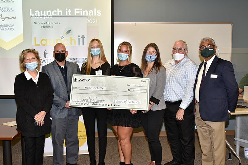 Student winners of the 2021 Launch It business competition pose with big check with faculty, dean of School of Business and competition judges.