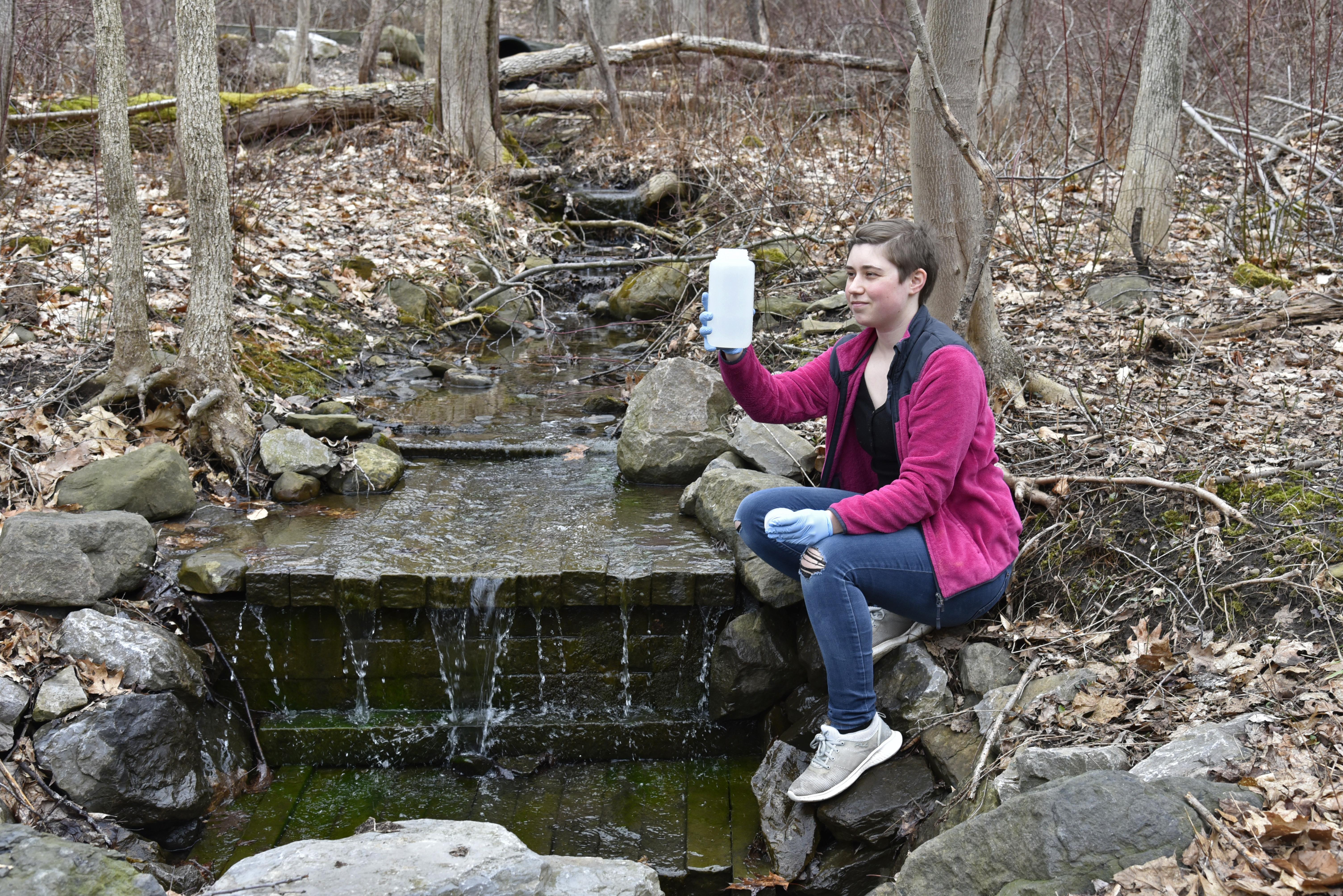 SUNY Oswego senior zoology major Jamie Perrin collects environmental DNA from recent winter melt