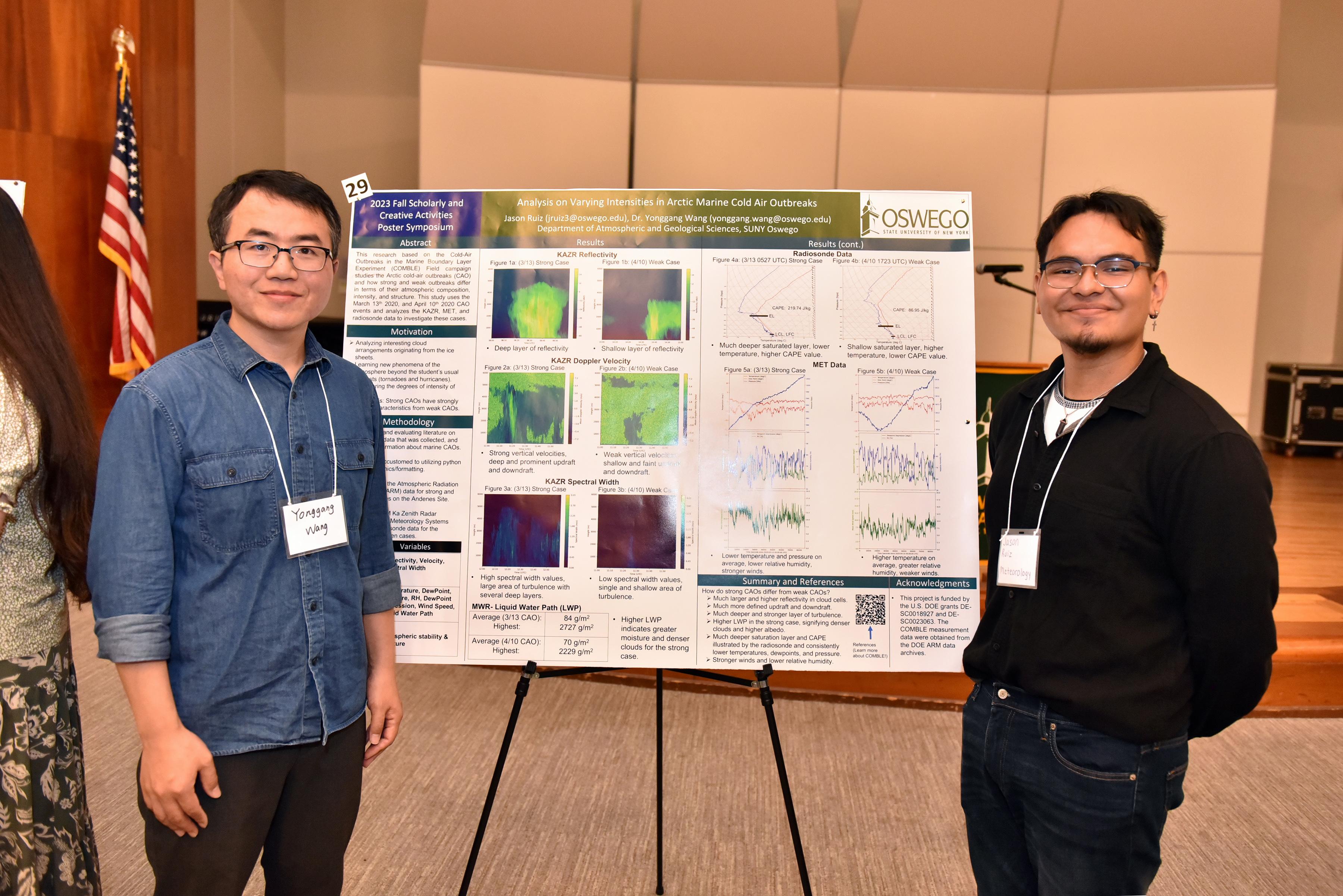 SUNY Oswego meteorology professor Yonggang Wang and his student Jason Ruiz stand in front of their poster presentation on arctic cold air outbreaks.