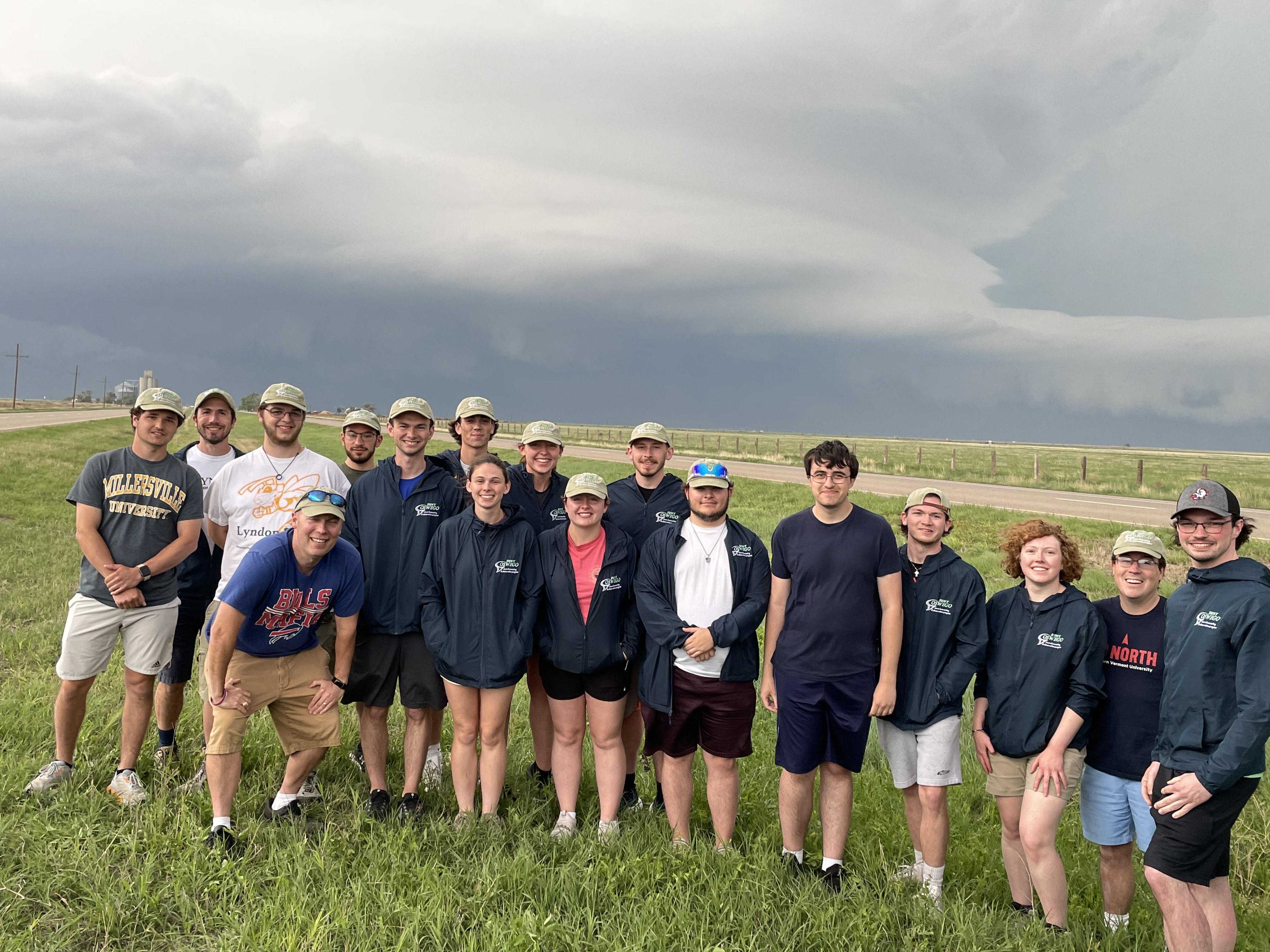 Professor Scott Steiger and his class stand in front of a stormy sky on their storm-chasing trip.