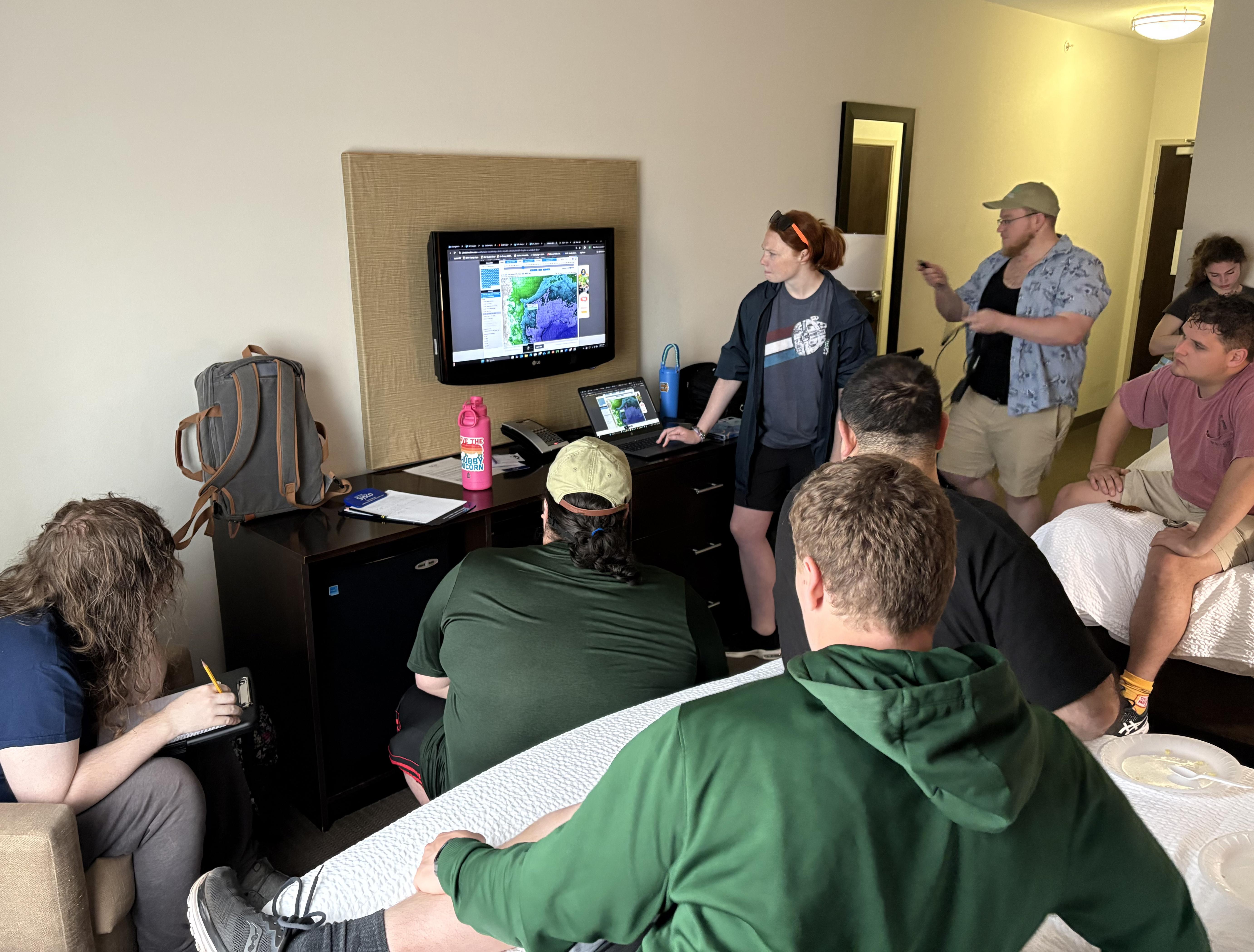 SUNY Oswego storm chasers gather in a hotel room on May 29 to discuss which weather conditions will be most favorable for potential tornadic activity.