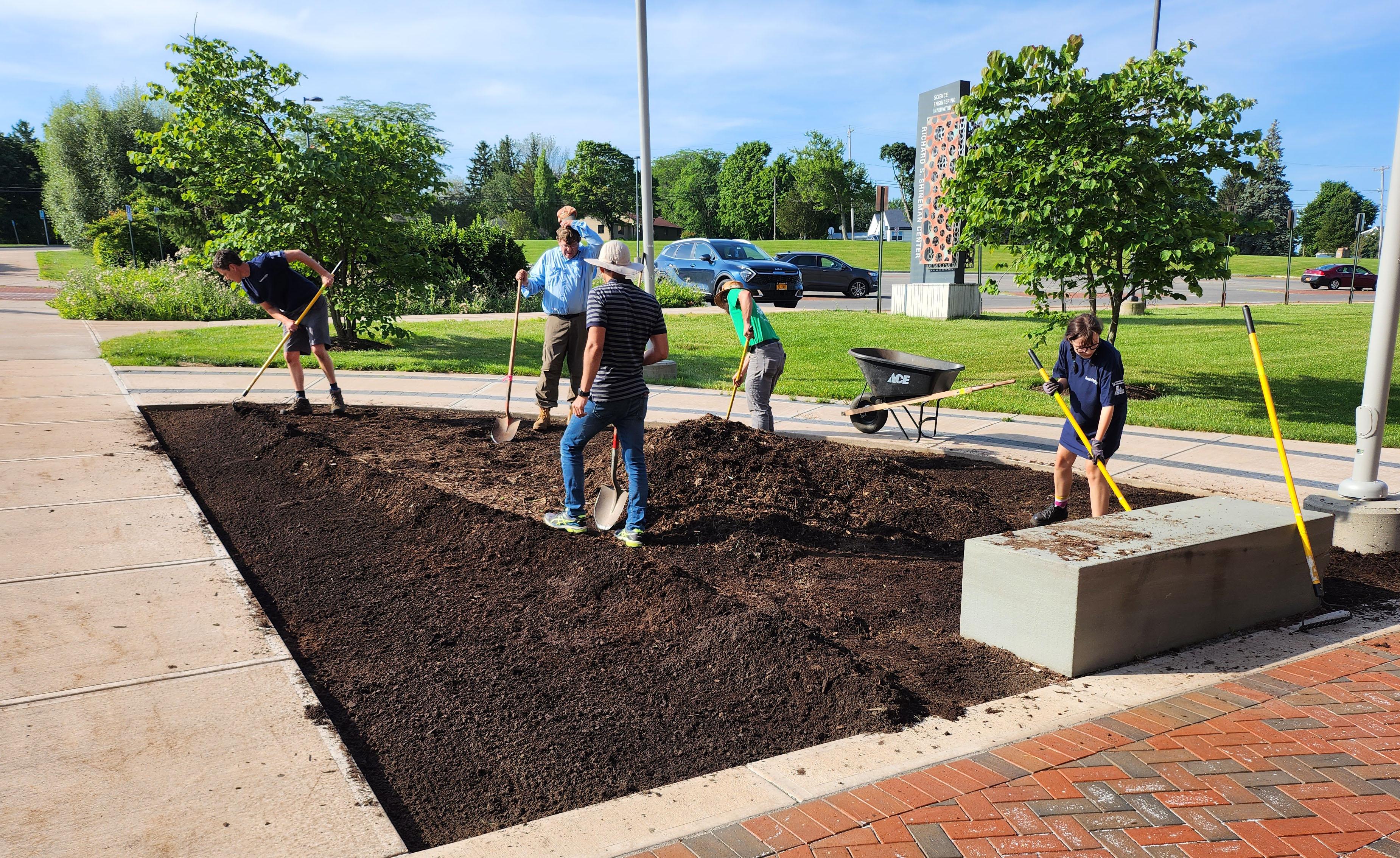 Student and staff volunteers planting the alvar garden outside Shineman Center.