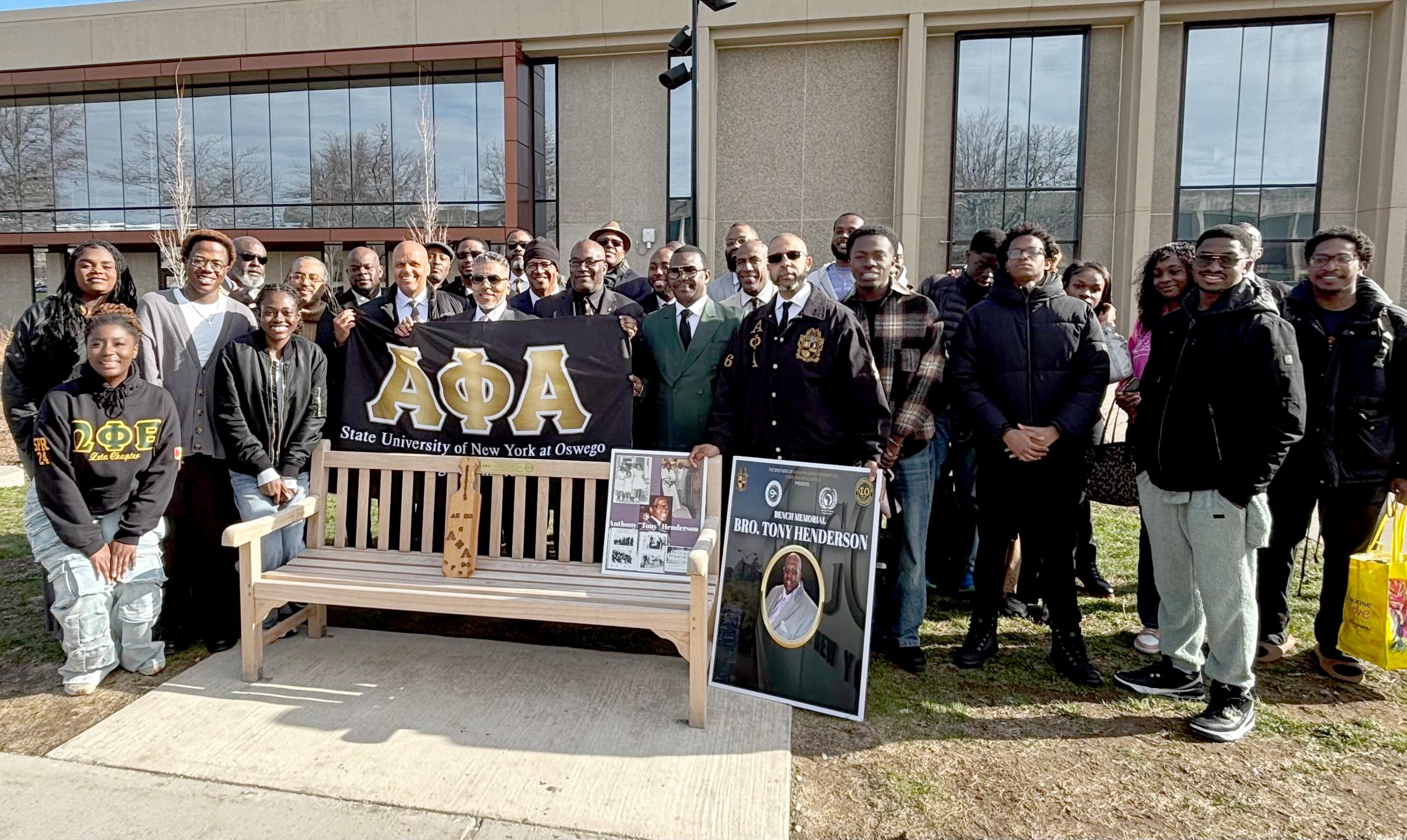 Members of Alpha Phi Alpha and the African Student Organization gather for the dedication of a bench to longtime residence hall director and mentor Tony Henderson