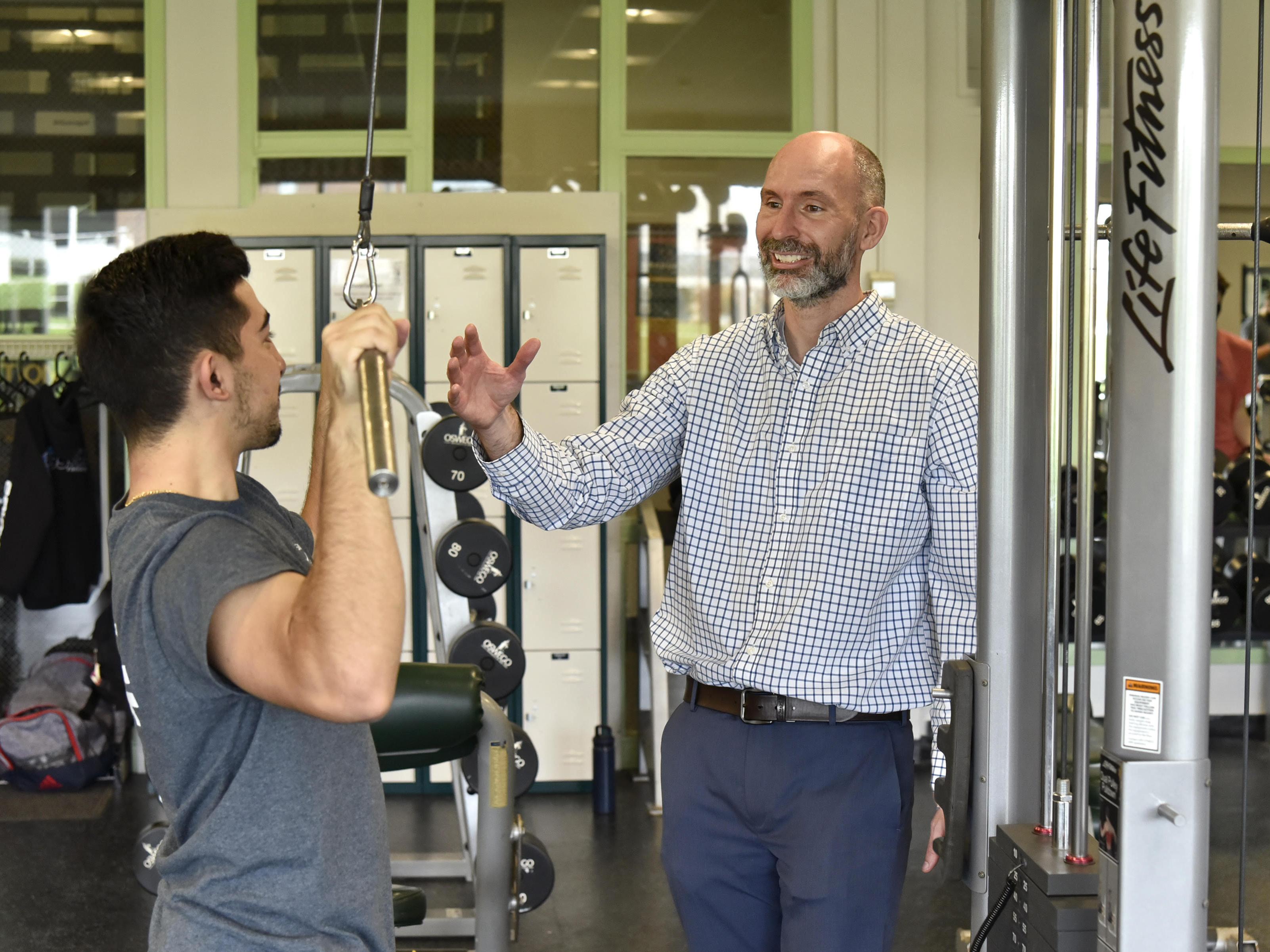 Brian Wallace in Cooper Fitness Center working with Panagiotis Vakirtzis, a junior business marketing major