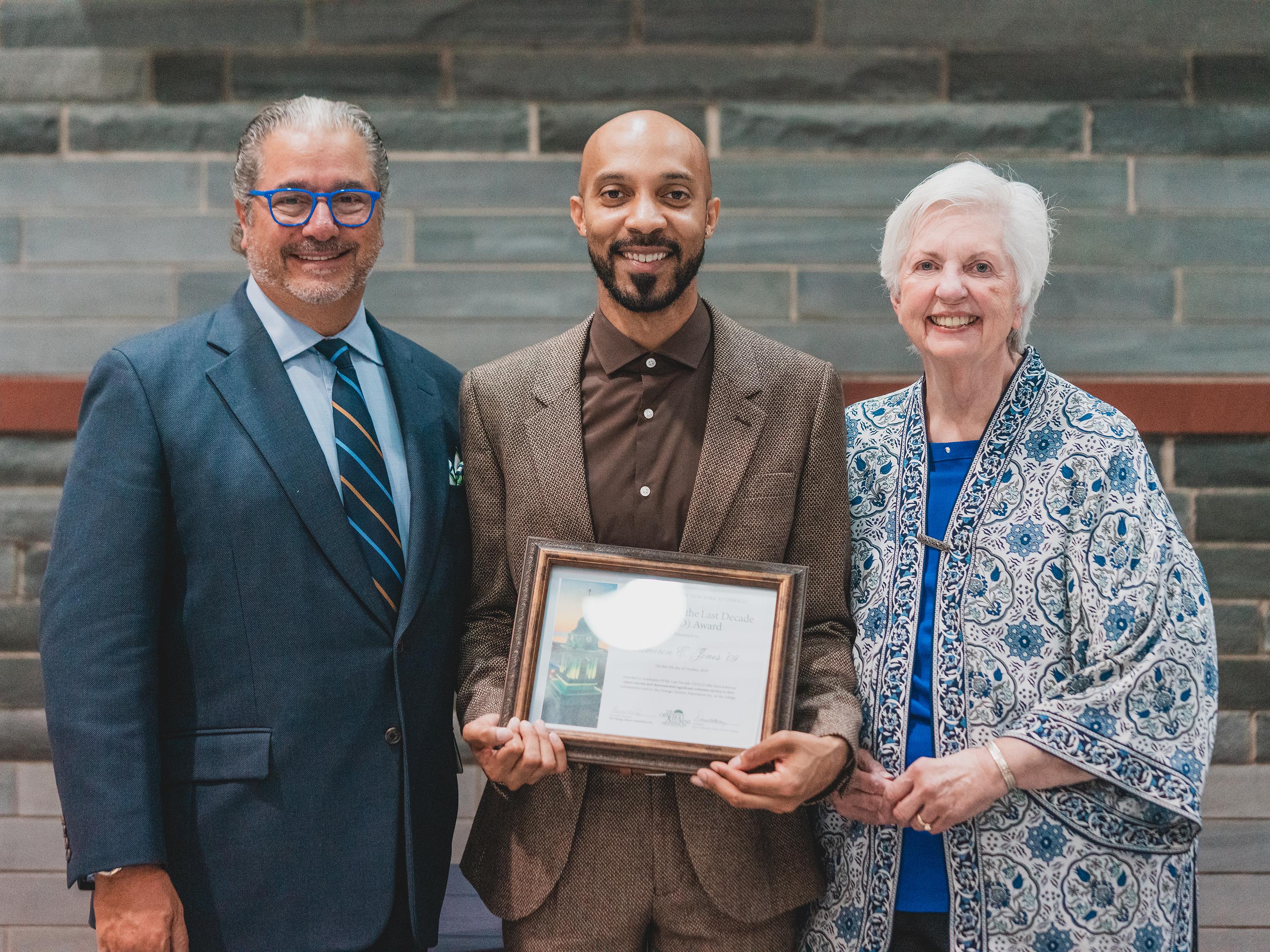 Three-time Emmy Award-winning producer Cameron Jones (center) of SUNY Oswego's Class of 2009 was honored recently by the Oswego Alumni Association with a Graduate Of the Last Decade Alumni Award