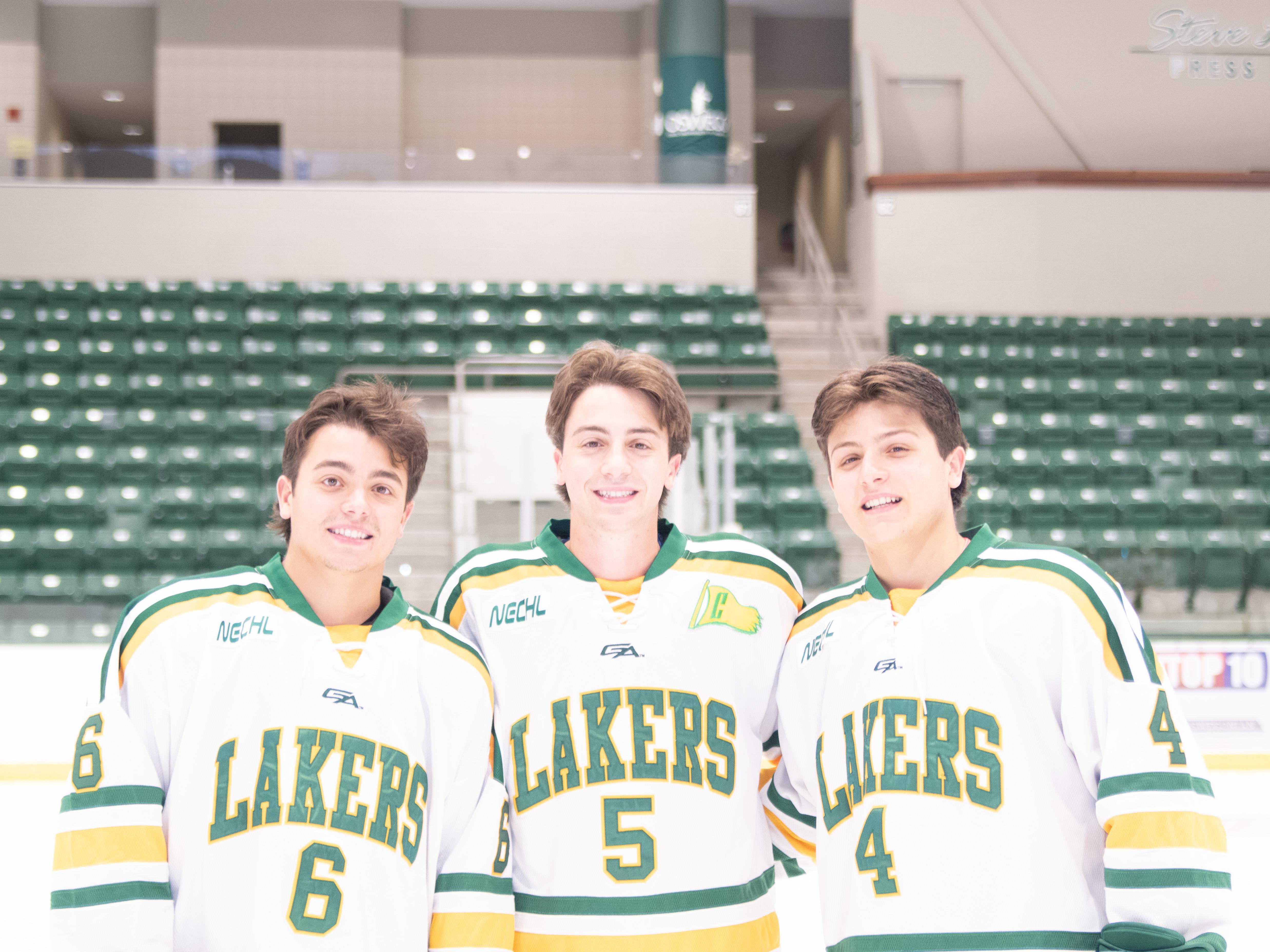 Matthew, Andrew, and Nicholas Cardi pose in hockey jerseys