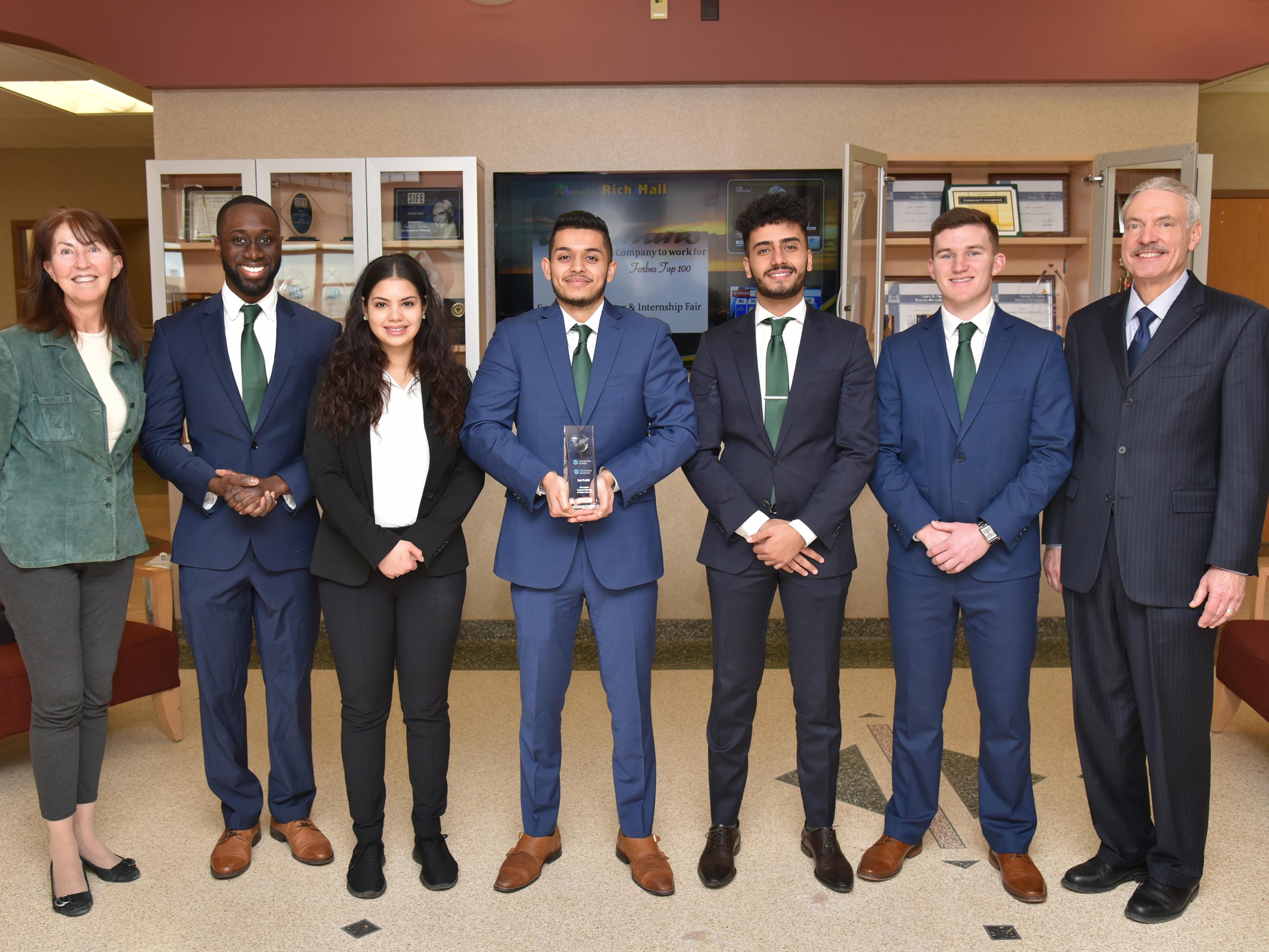 Members of Oswego's team in the SUNY Oswego CFA Research Challenge Team present Dean Richard Skolnik with a trophy