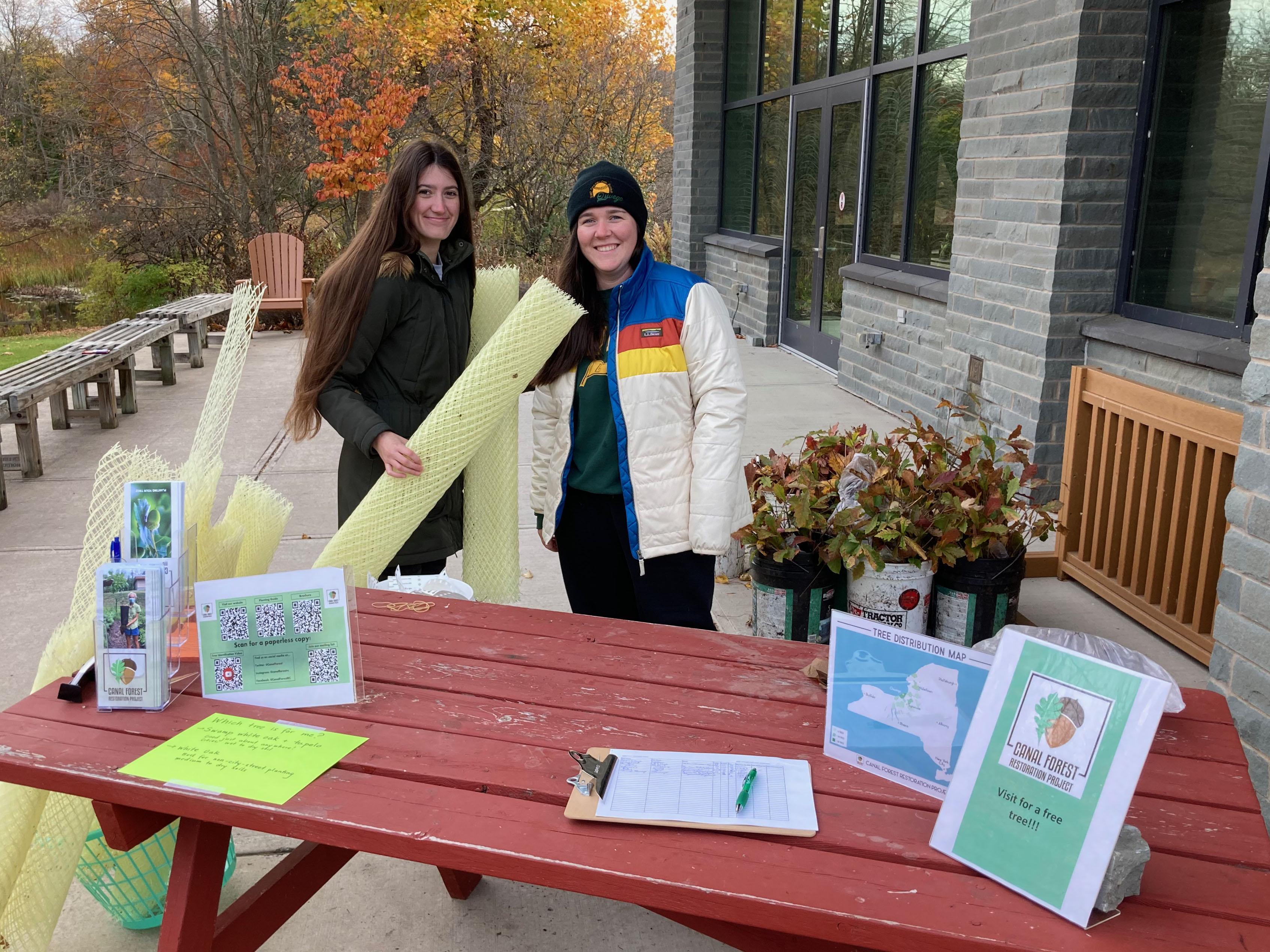 Canal Forest Restoration Project interns Julia Zinszer and Elizabeth Triana show some plants