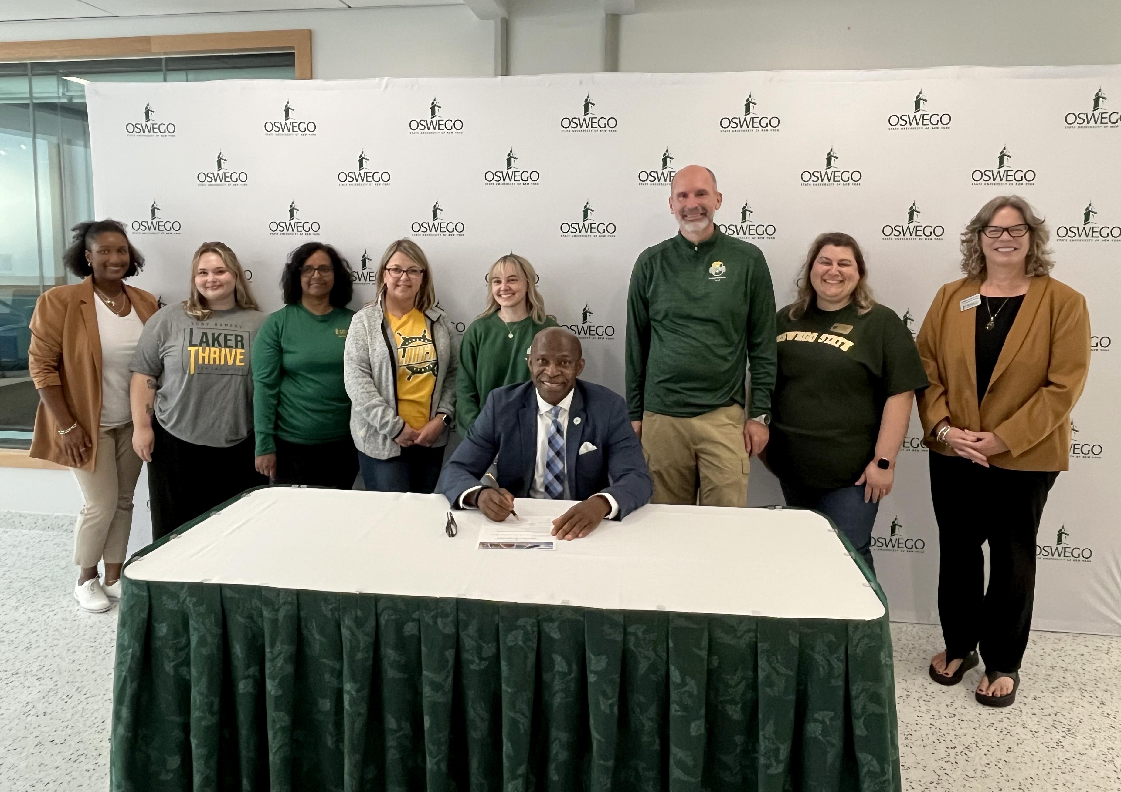 President Peter O. Nwosu, joined by members of SUNY Oswego's Campus Health and Well-being Committee, makes SUNY Oswego's participation the Okanagan Charter official with a charter signing on Friday, Sept. 26.