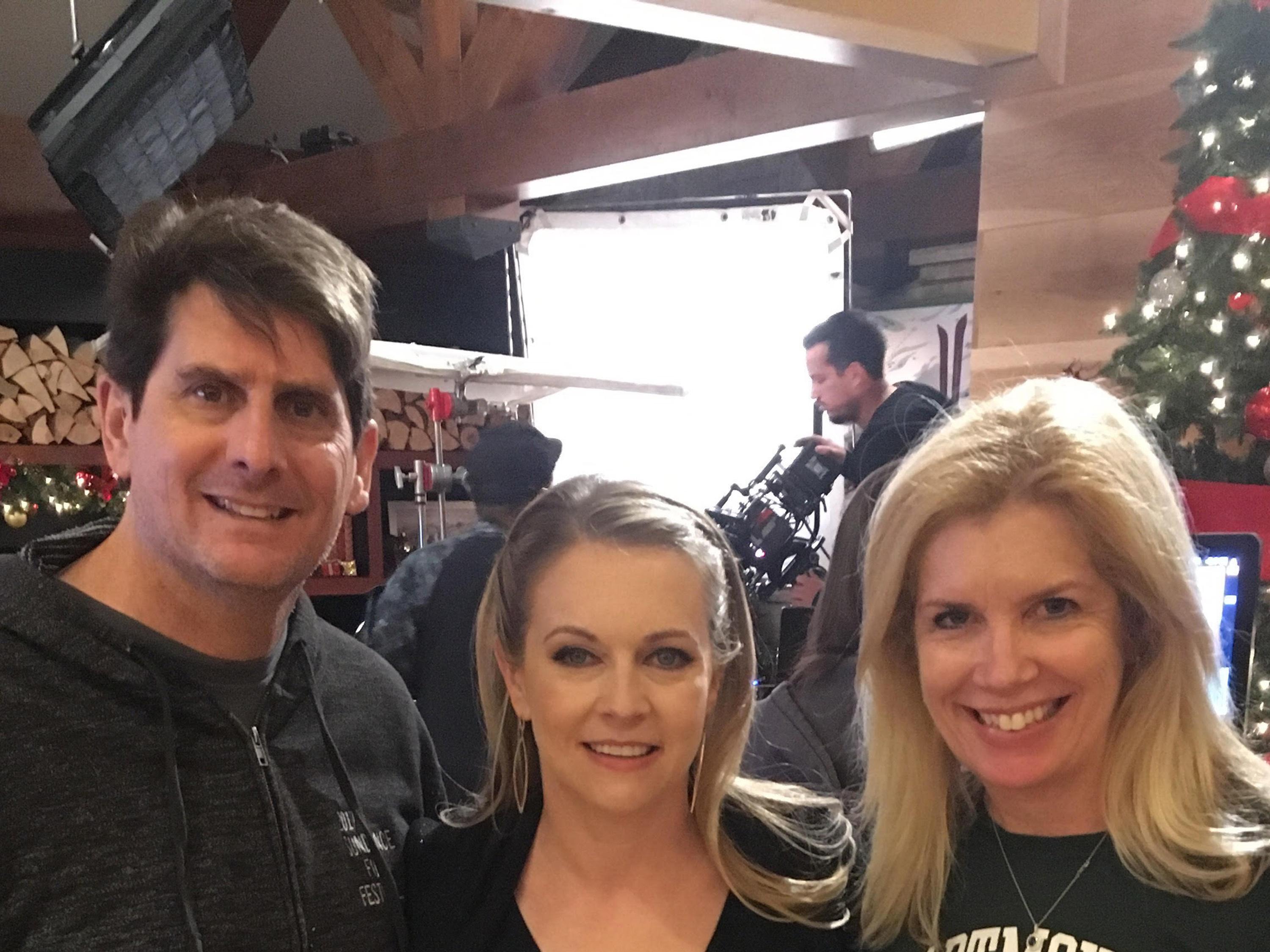 Juliet Giglio, her husband Keith and star Melissa Joan Hart on set of their Hallmark movie Christmas Reservations