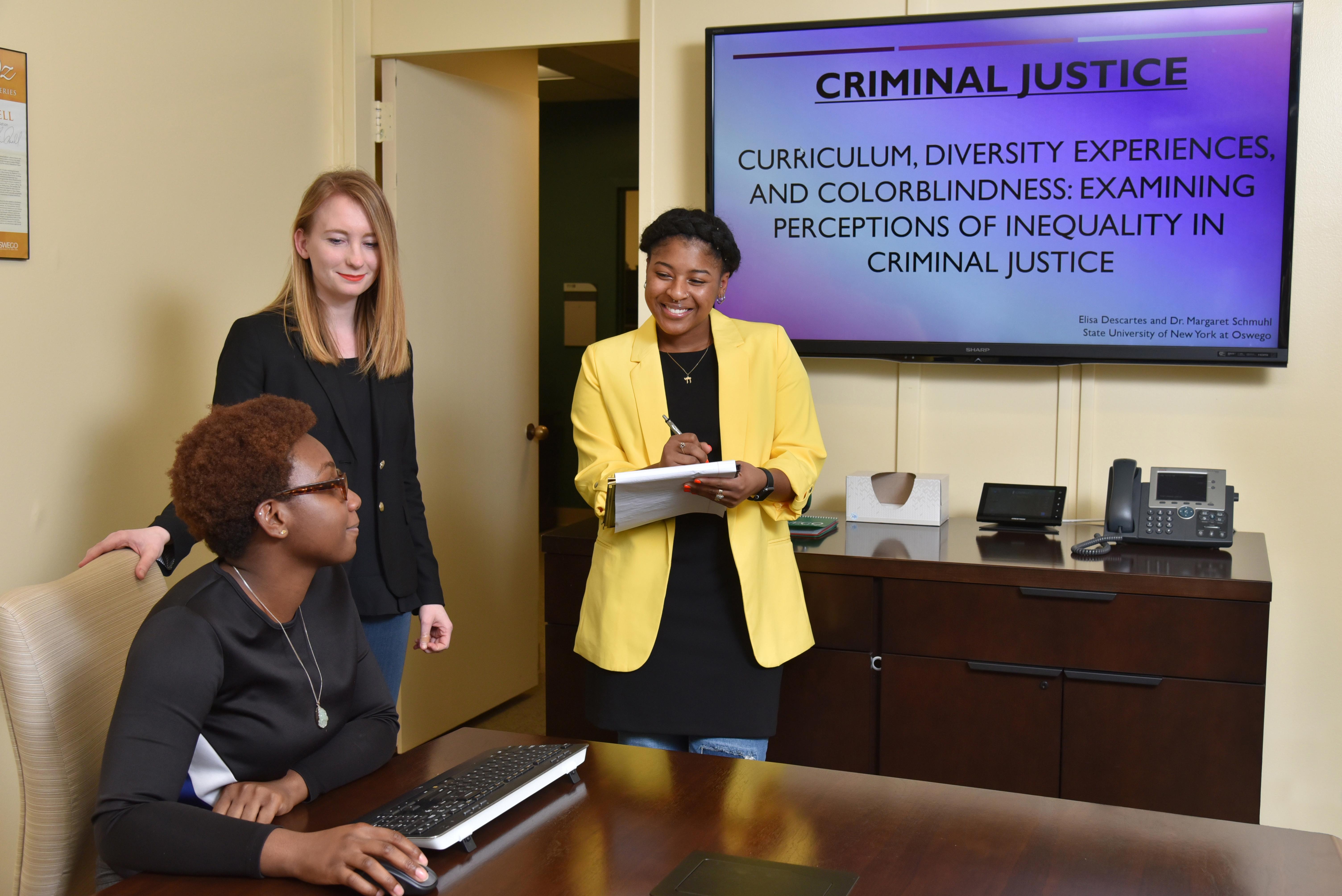 Criminal justice faculty member listening to student presentations