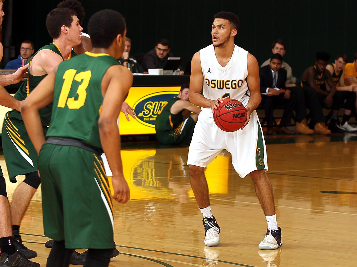 Laker men's basketball player dribbles the ball against defenders, looking for an opening