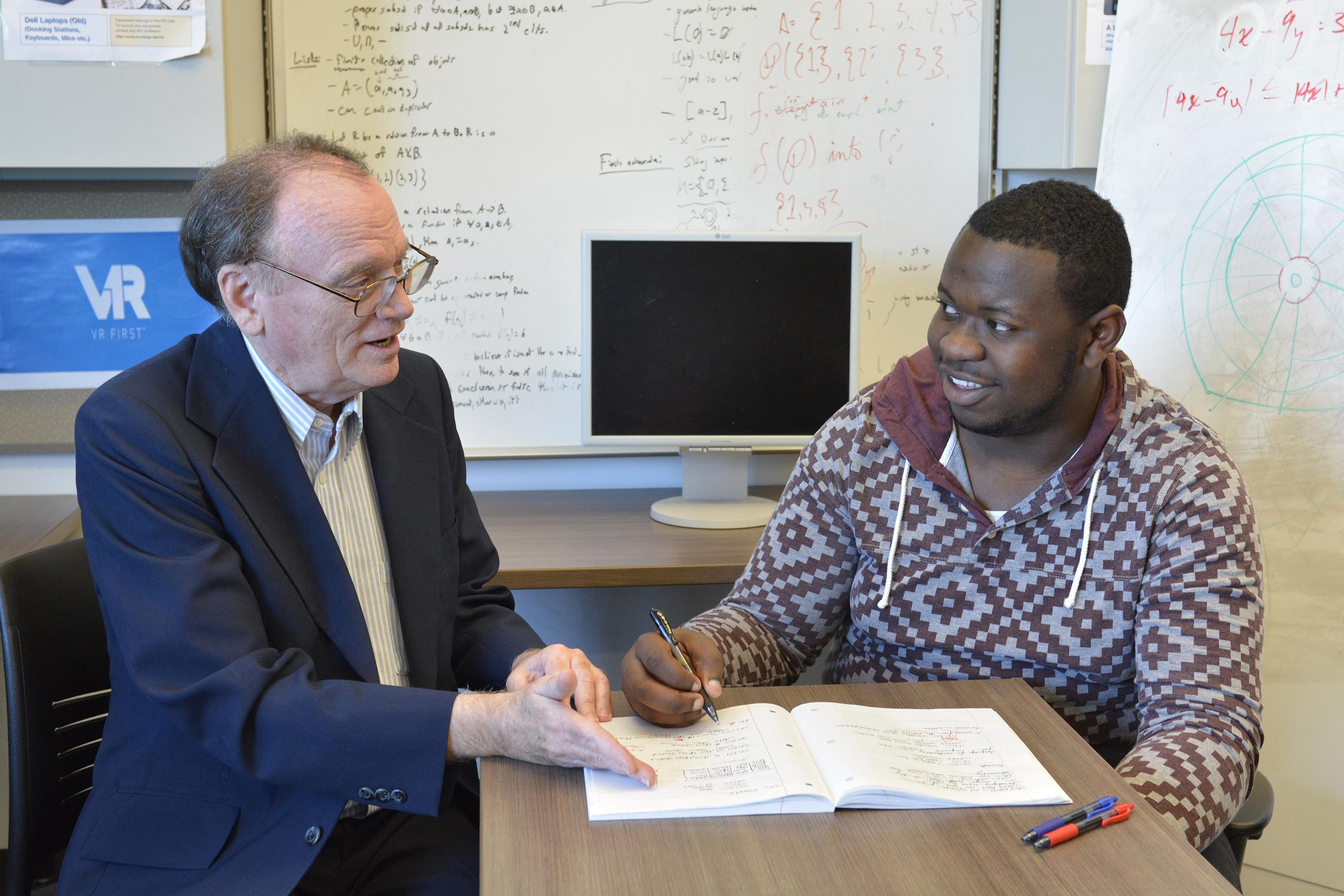 Faculty member David Vampola speaks with student Kingsley Ibezim