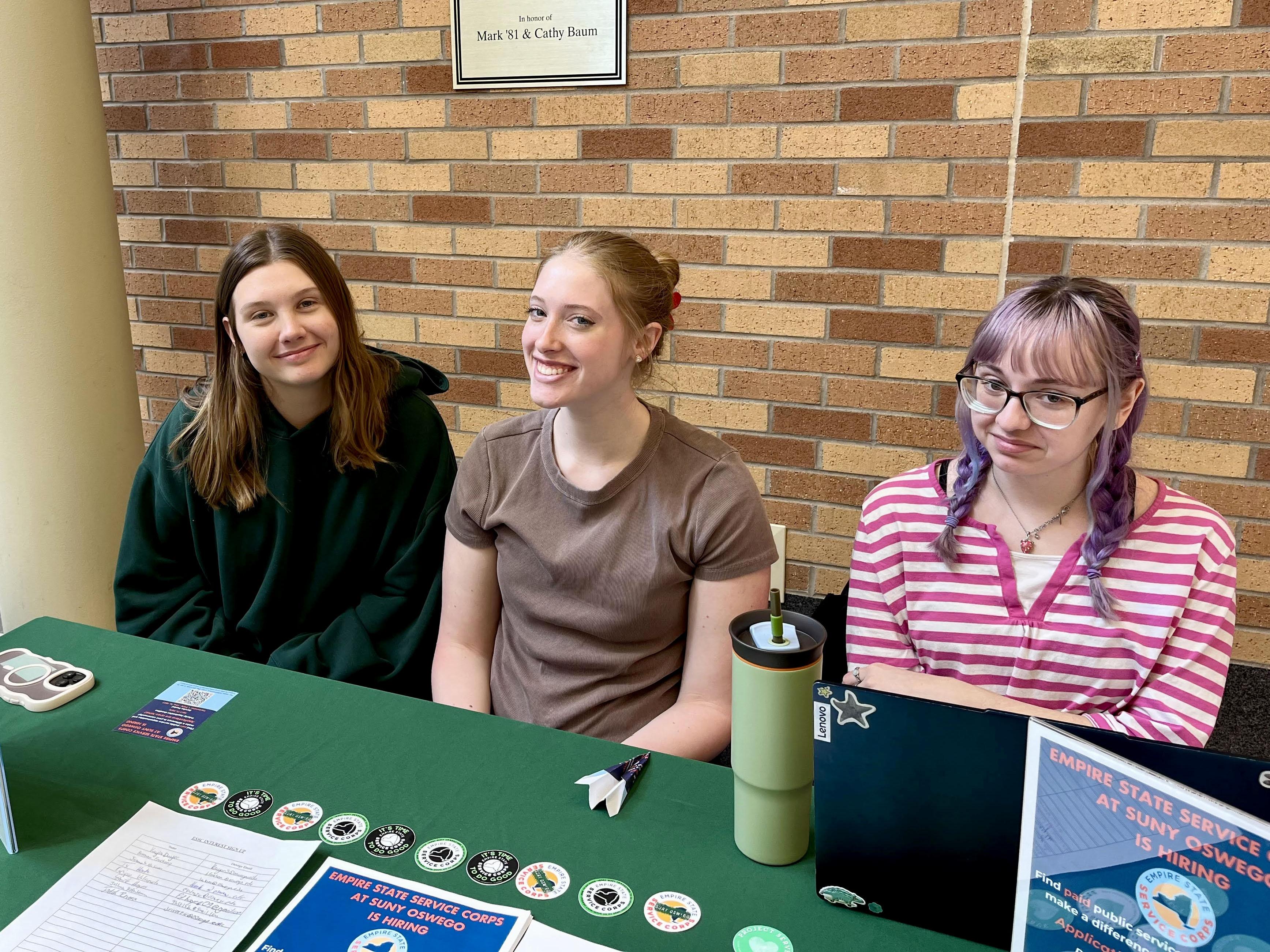 Current Empire State Service Corps members, from left, Arrissa Bunker, Ruby Ramseyer and Jasmine VanAntwerp, host a table in Marano Campus Center to inform students about opportunities through the paid program