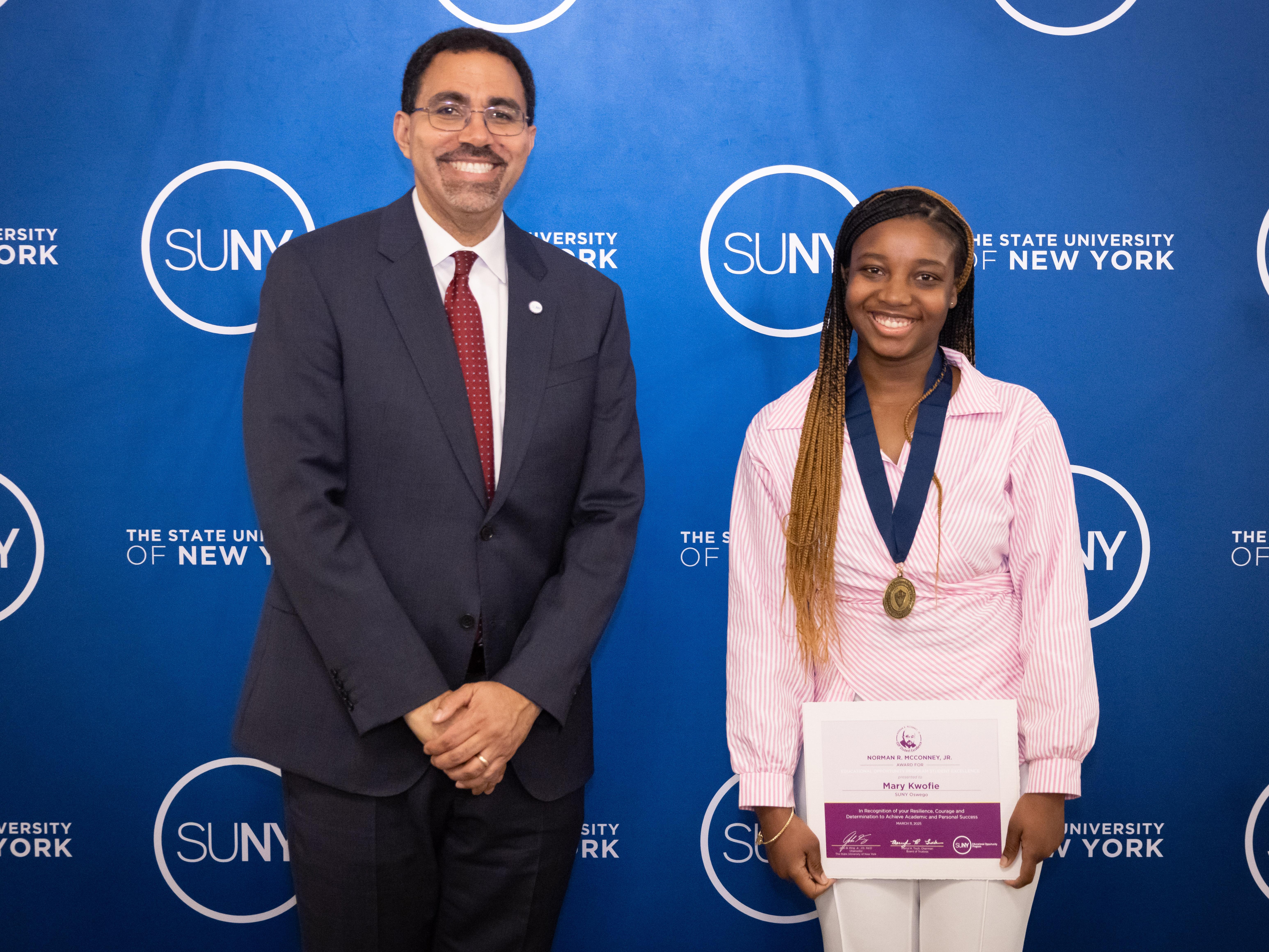 Chancellor John B. King Jr. congratulations SUNY Oswego student Mary Kwofie during an award ceremony